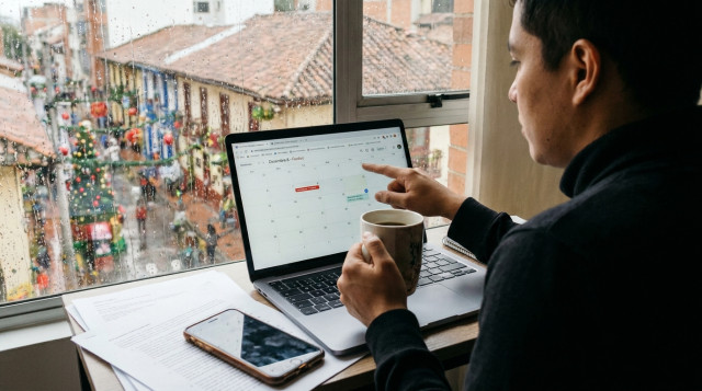 persona en Colombia revisando el calendario en su computador para radicar trámites en línea en día festivo antes del vencimiento del plazo