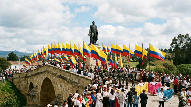 El monumento del Puente de Boyacá con la estatua de Simón Bolívar rodeado de banderas de Colombia durante la celebración de qué se celebra el 7 de agosto en Colombia