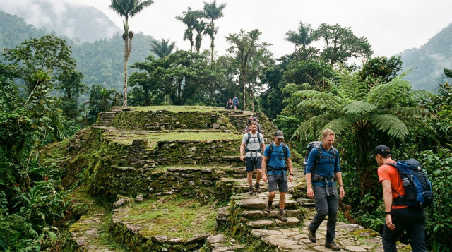 Caminantes ascendiendo por los escalones de piedra originales de la Ciudad Perdida rodeados de vegetación selvática