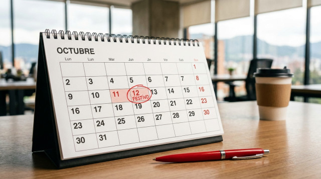 calendario de sobremesa abierto en octubre con el recuadro del 12 de octubre resaltado en rojo, fondo de oficina y un bolígrafo; texto alternativo con la palabra clave